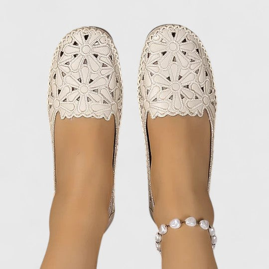 White - Women's slip-on loafers featuring a faux-leather upper with detailed floral cutouts, scalloped edges, and a textured flat sole.