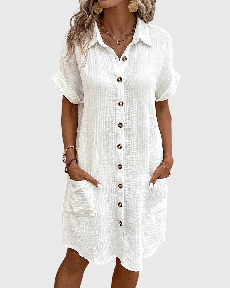 White - A woman wearing a white, short-sleeved cotton gauze button-down shirt dress with front patch pockets and a pointed collar.