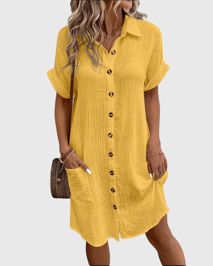 Yellow - A woman wearing a white, short-sleeved cotton gauze button-down shirt dress with front patch pockets and a pointed collar.