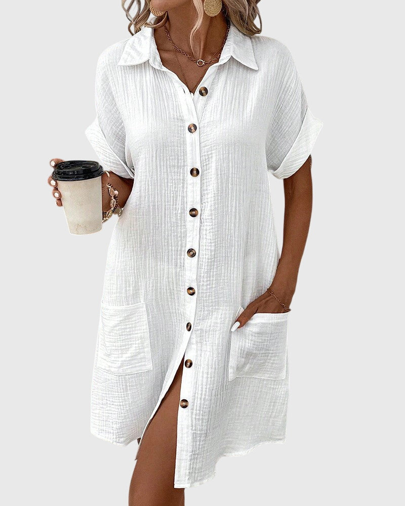 Olive Green - A woman wearing a white, short-sleeved cotton gauze button-down shirt dress with front patch pockets and a pointed collar.
