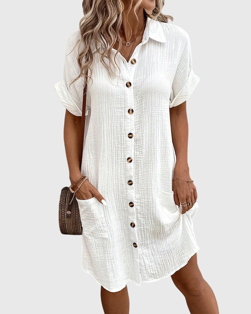 Olive Green - A woman wearing a white, short-sleeved cotton gauze button-down shirt dress with front patch pockets and a pointed collar.