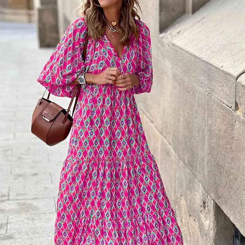 Pink - Woman wearing a long sleeve geometric print tiered maxi dress with puff sleeves walking on a sidewalk