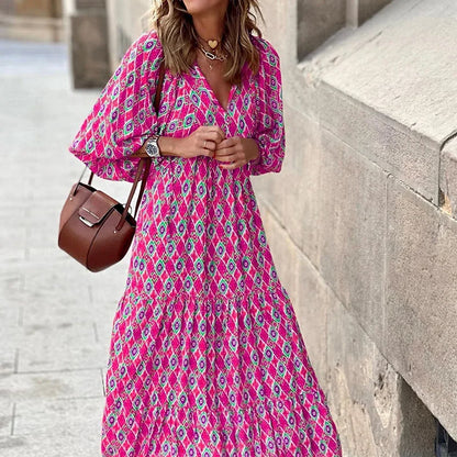 Pink - Woman wearing a long sleeve geometric print tiered maxi dress with puff sleeves walking on a sidewalk
