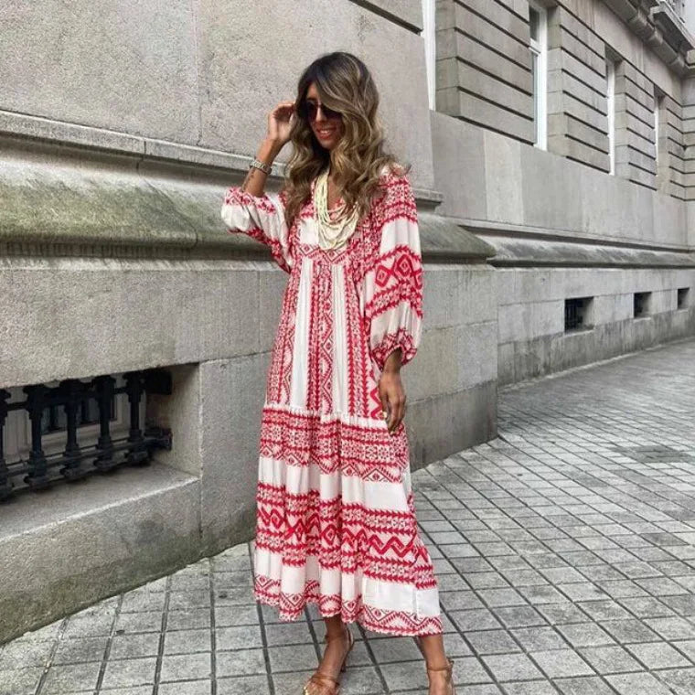 Red - Woman wearing a long sleeve geometric print tiered maxi dress with puff sleeves walking on a sidewalk