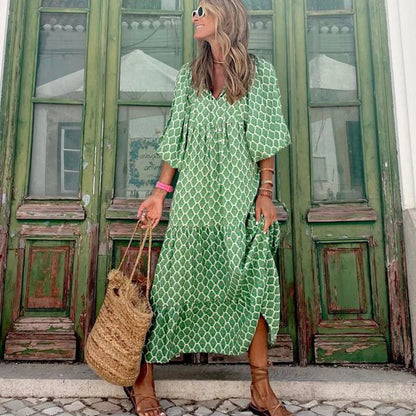 Green - Woman wearing a long sleeve geometric print tiered maxi dress with puff sleeves walking on a sidewalk