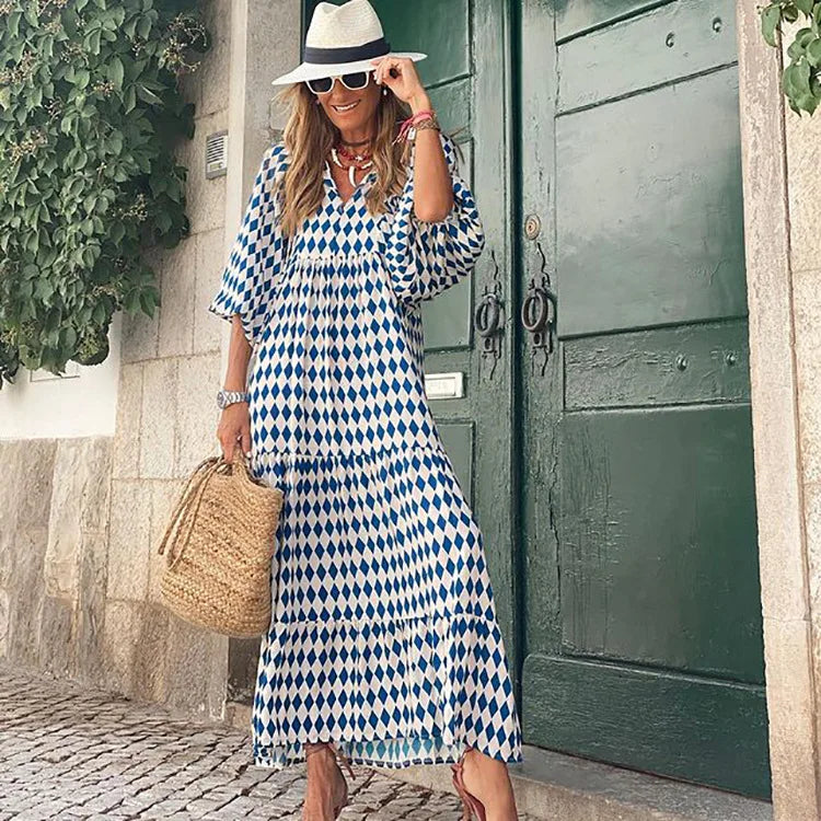 Blue - Woman wearing a long sleeve geometric print tiered maxi dress with puff sleeves walking on a sidewalk