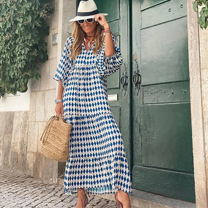 Blue - Woman wearing a long sleeve geometric print tiered maxi dress with puff sleeves walking on a sidewalk