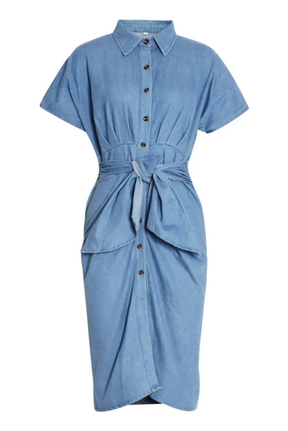 Woman in light blue denim shirt dress with tie waist.