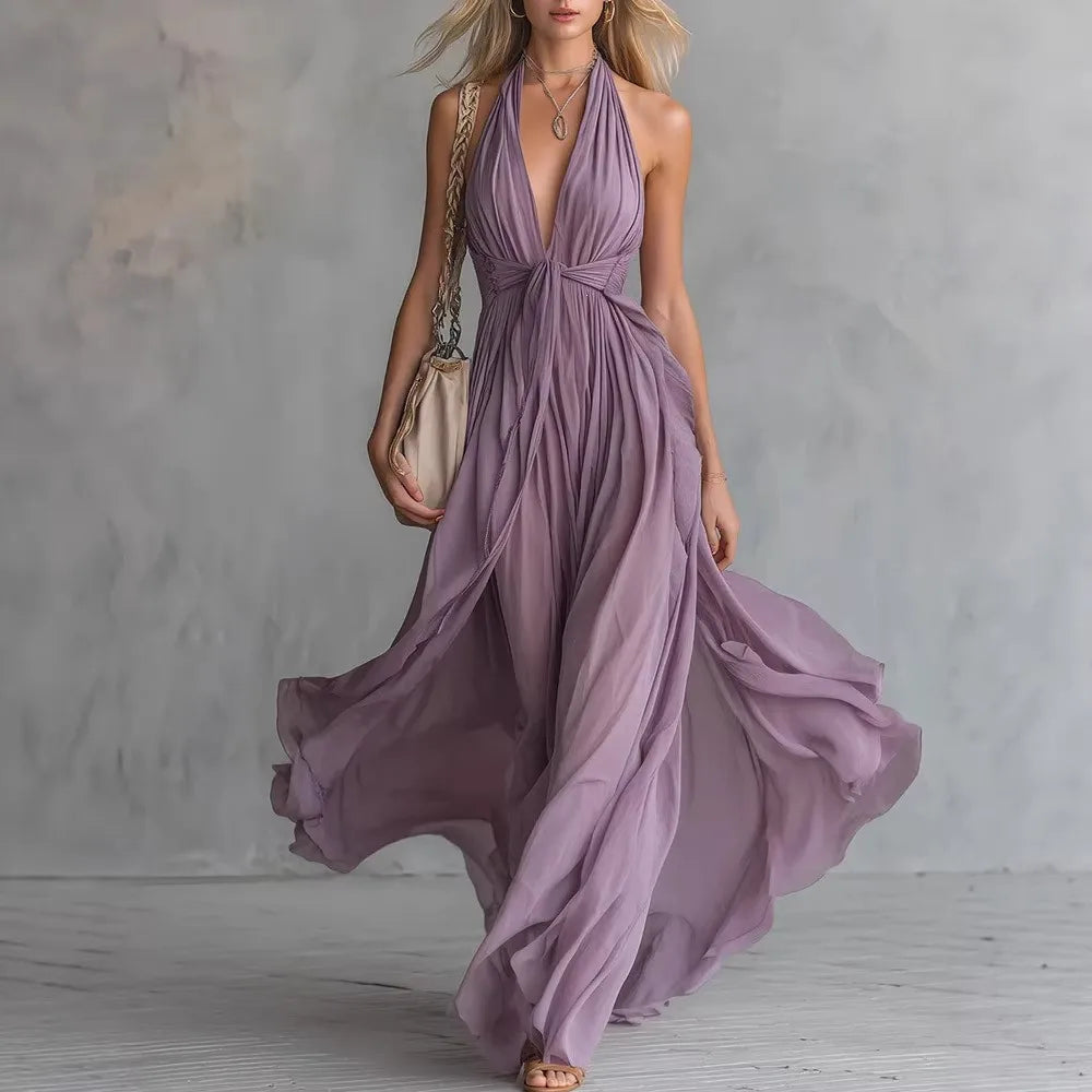 Purple - A woman wearing a dusty lavender chiffon halter maxi dress with a plunging V-neckline, pleated bodice, and a flowing floor-length skirt.