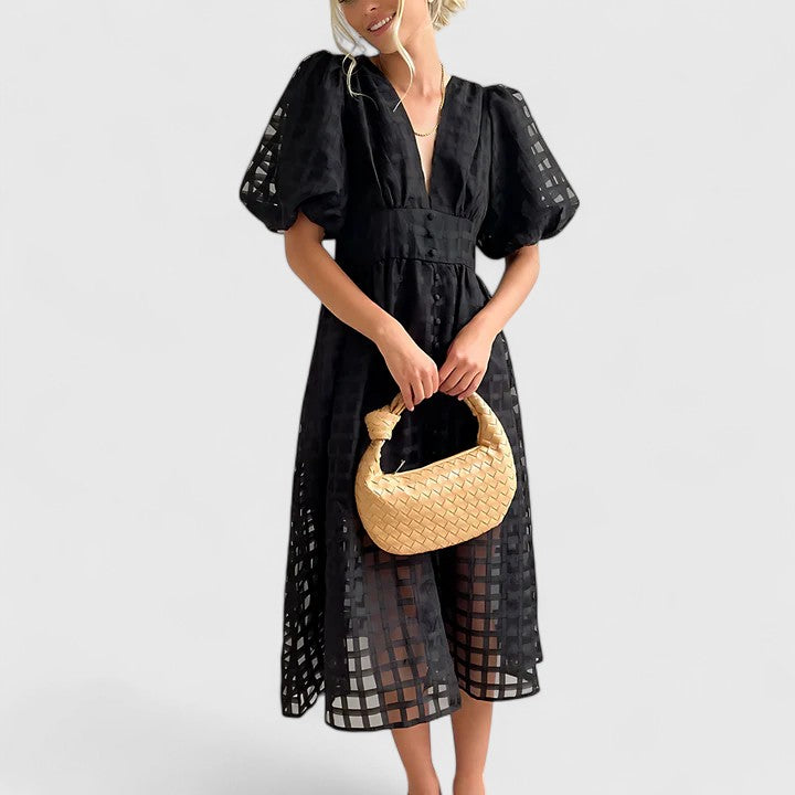 Black - A woman wearing a black grid organza midi dress with puff sleeves, a deep V-neck, and a button-front bodice, holding a woven beige handbag.