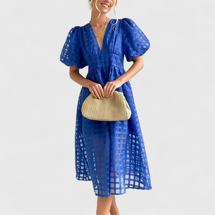Blue - A woman wearing a black grid organza midi dress with puff sleeves, a deep V-neck, and a button-front bodice, holding a woven beige handbag.