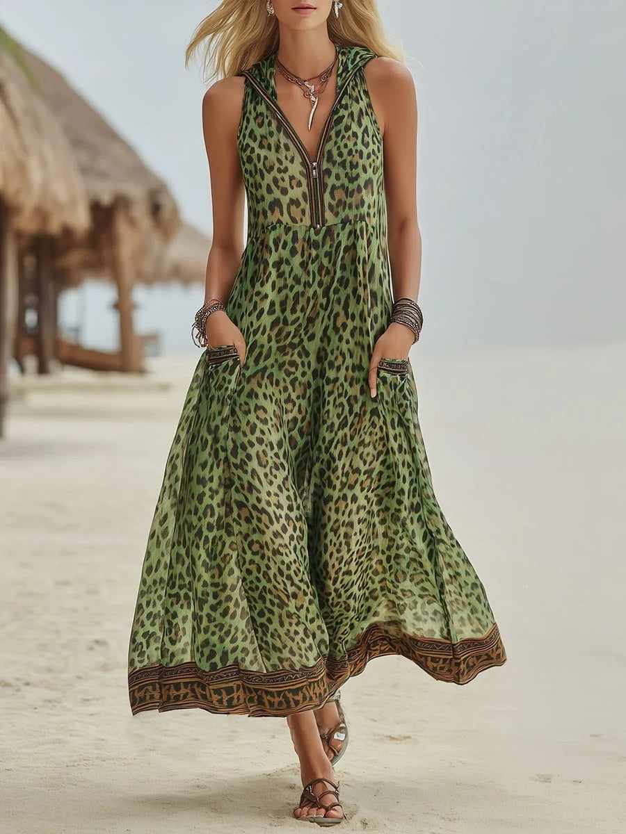Green - A woman walks on a sandy beach wearing a sleeveless, hooded green leopard print chiffon maxi dress with a zip-front neckline and side pockets.