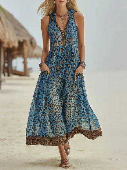 Blue - A woman walks on a sandy beach wearing a sleeveless, hooded green leopard print chiffon maxi dress with a zip-front neckline and side pockets.