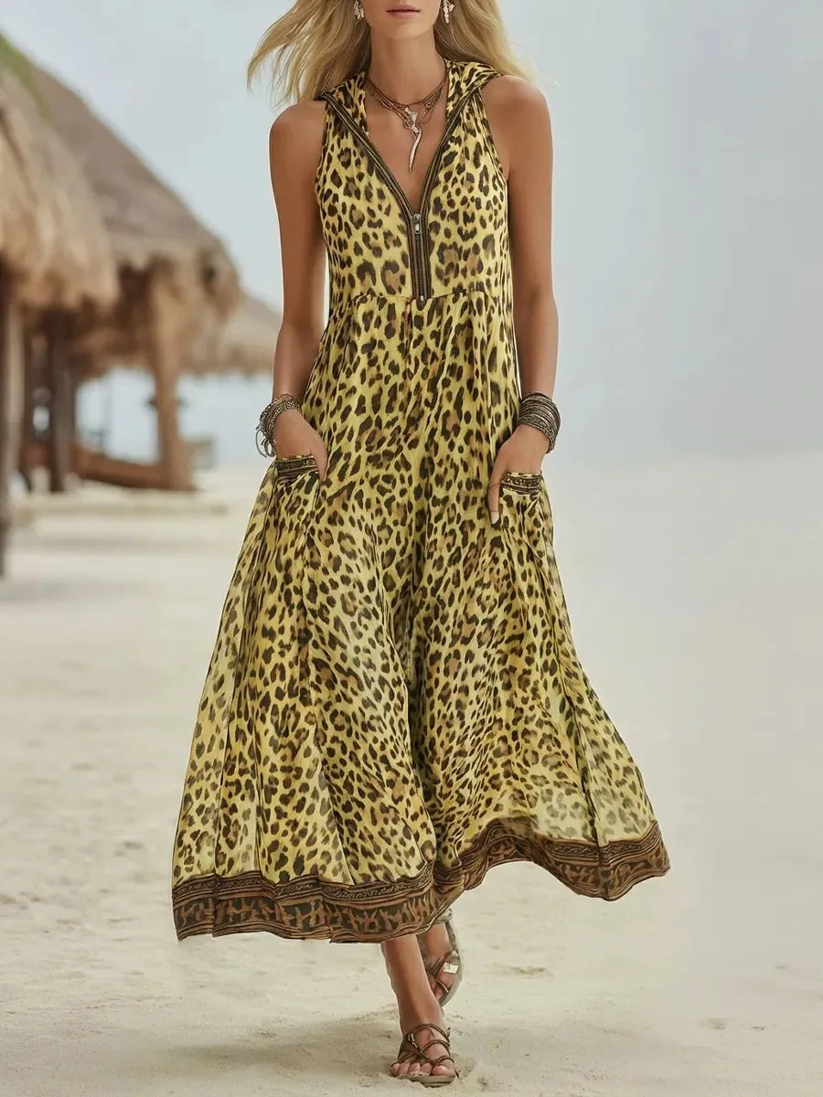 Yellow - A woman walks on a sandy beach wearing a sleeveless, hooded green leopard print chiffon maxi dress with a zip-front neckline and side pockets.