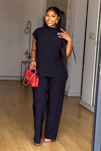 Woman in black linen pant set with red handbag