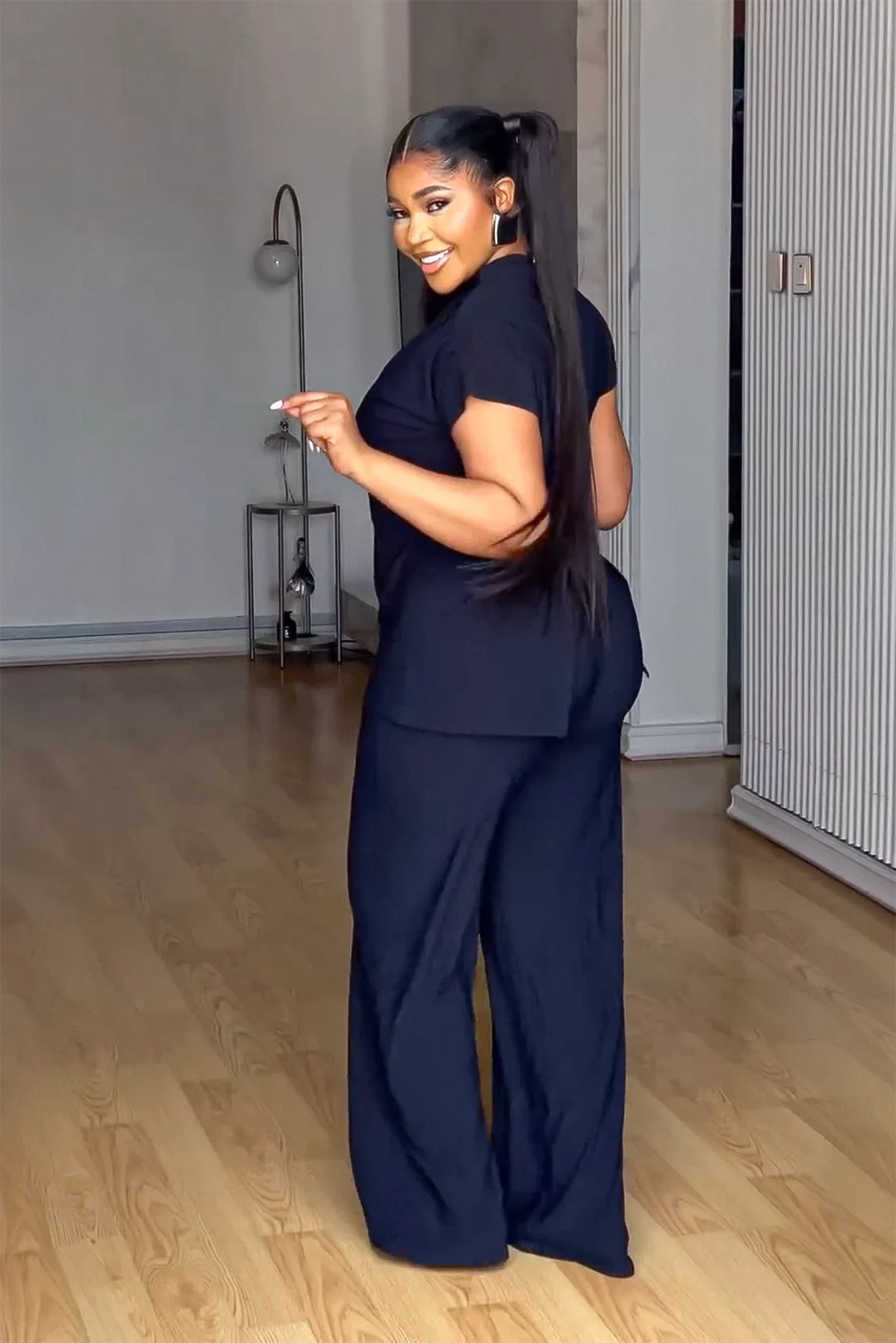 Woman in black linen pant set with red handbag