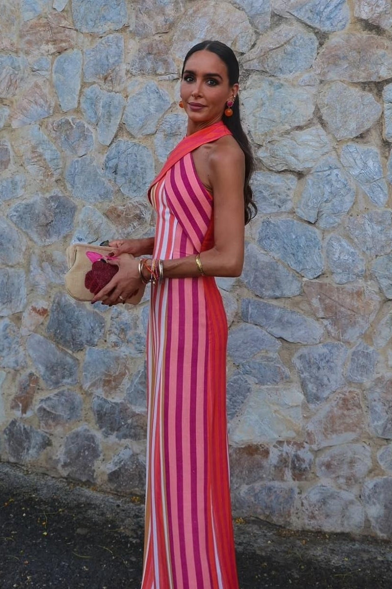 A woman wearing a striped pink and orange linen maxi dress.