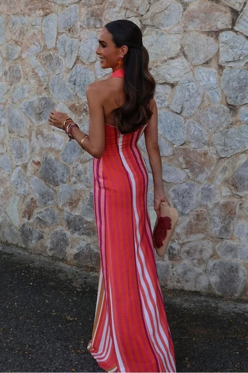 A woman wearing a striped pink and orange linen maxi dress.