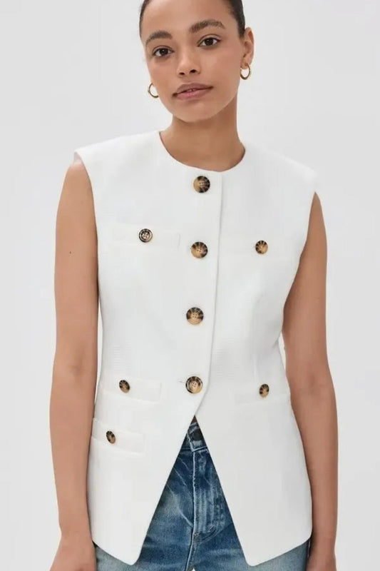 Woman wearing white boucle vest with tortoise buttons