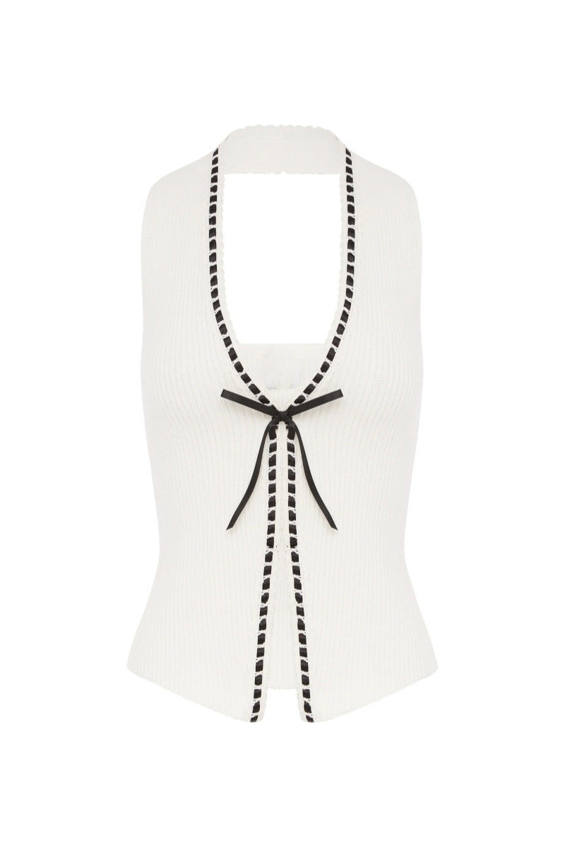 Woman in white ribbed knit halter top with black trim and tie front.