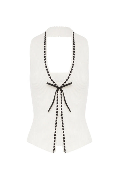 Woman in white ribbed knit halter top with black trim and tie front.