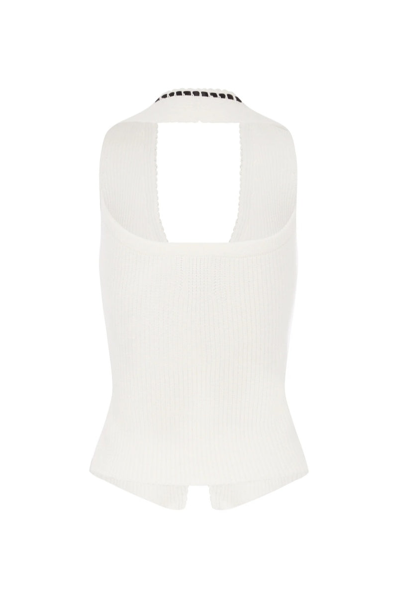 Woman in white ribbed knit halter top with black trim and tie front.
