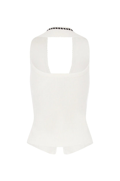 Woman in white ribbed knit halter top with black trim and tie front.