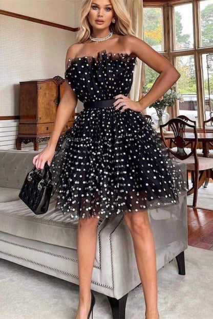 Woman in black and white polka dot tulle mini dress with belt
