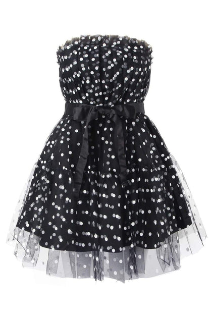 Woman in black and white polka dot tulle mini dress with belt