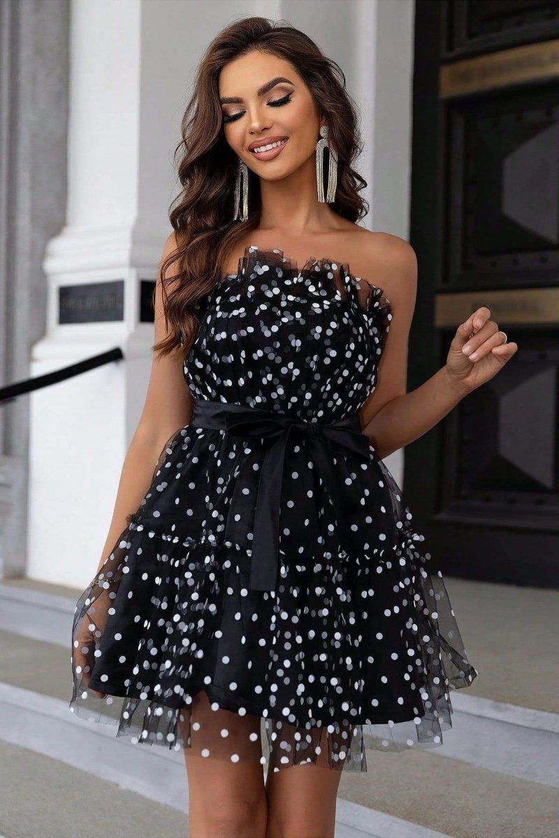 Woman in black and white polka dot tulle mini dress with belt