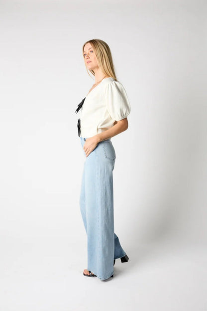 Woman wearing ivory ribbed knit cardigan with black bows