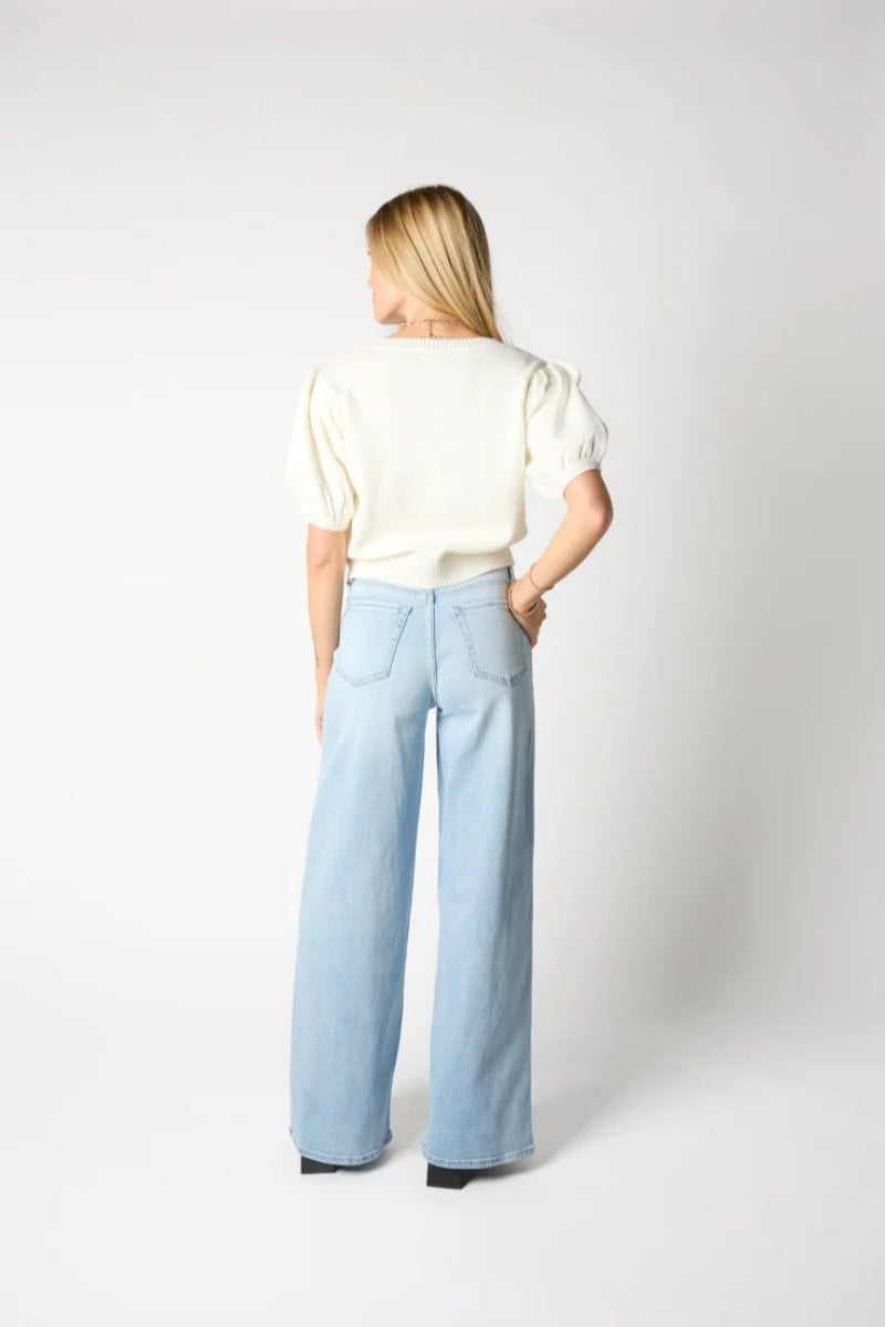 Woman wearing ivory ribbed knit cardigan with black bows