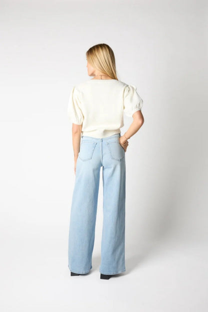 Woman wearing ivory ribbed knit cardigan with black bows