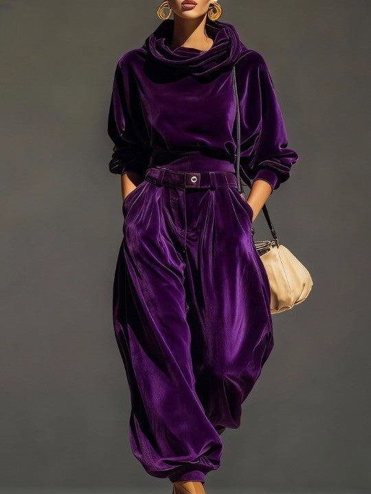 Woman wearing brown velvet cowl neck top and wide leg pants with cream-colored purse.