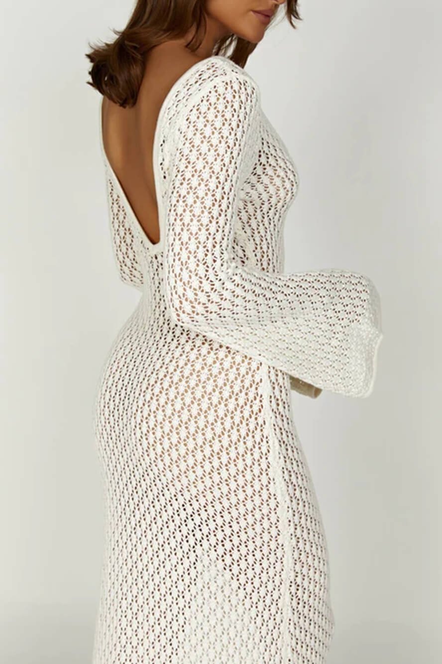 Woman wearing a long white crochet dress with a light blue purse.