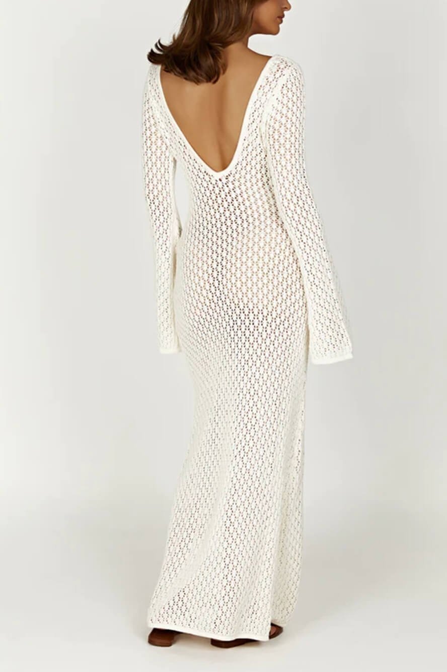 Woman wearing a long white crochet dress with a light blue purse.