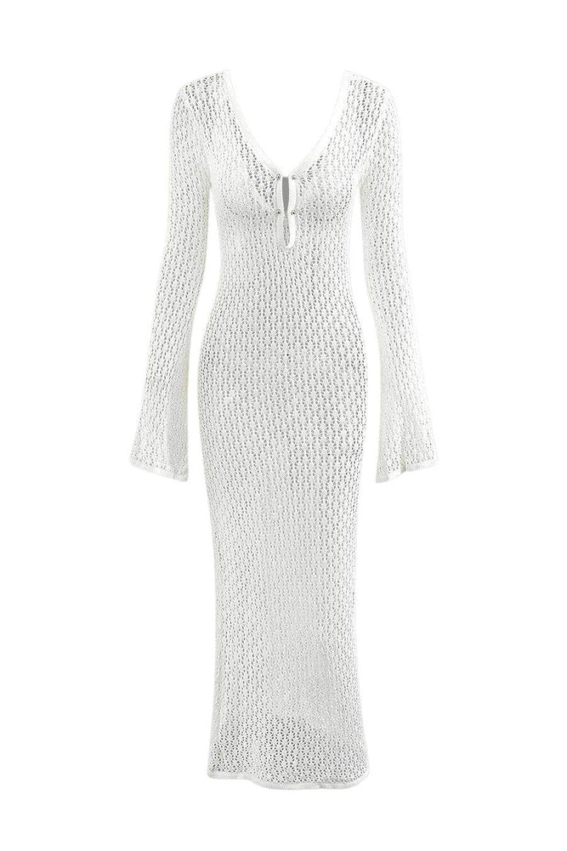 Woman wearing a long white crochet dress with a light blue purse.