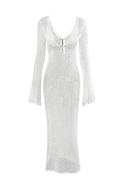 Woman wearing a long white crochet dress with a light blue purse.