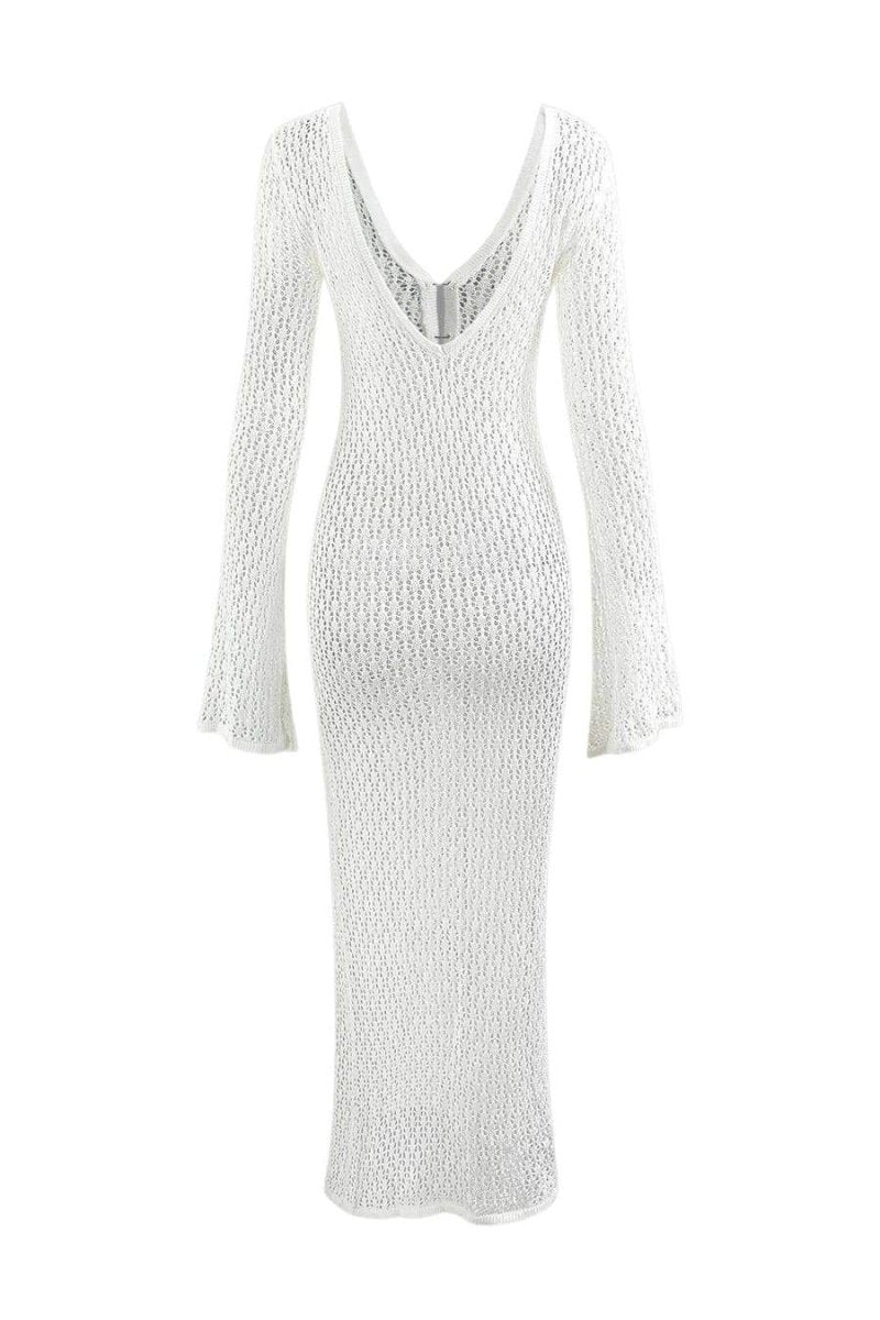 Woman wearing a long white crochet dress with a light blue purse.