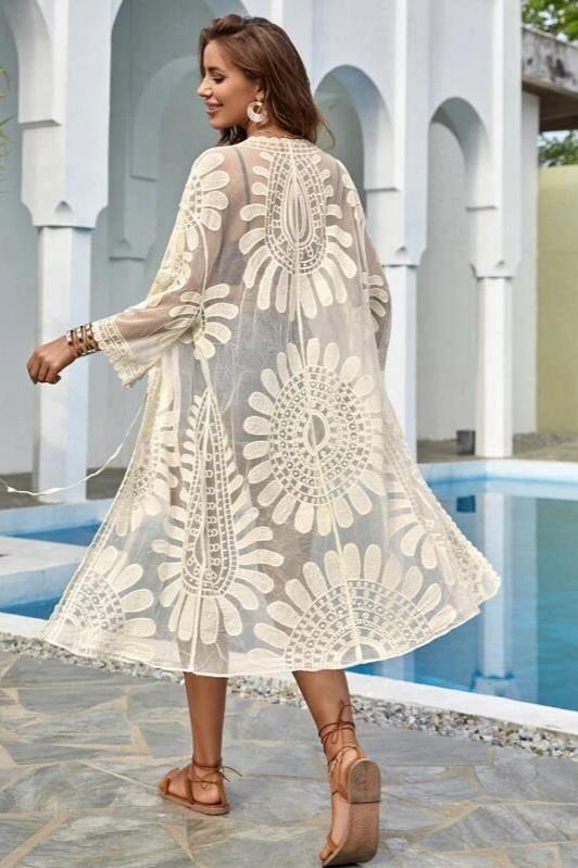 Woman in white sheer floral lace kimono over black bikini