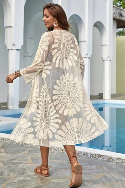 Woman in white sheer floral lace kimono over black bikini