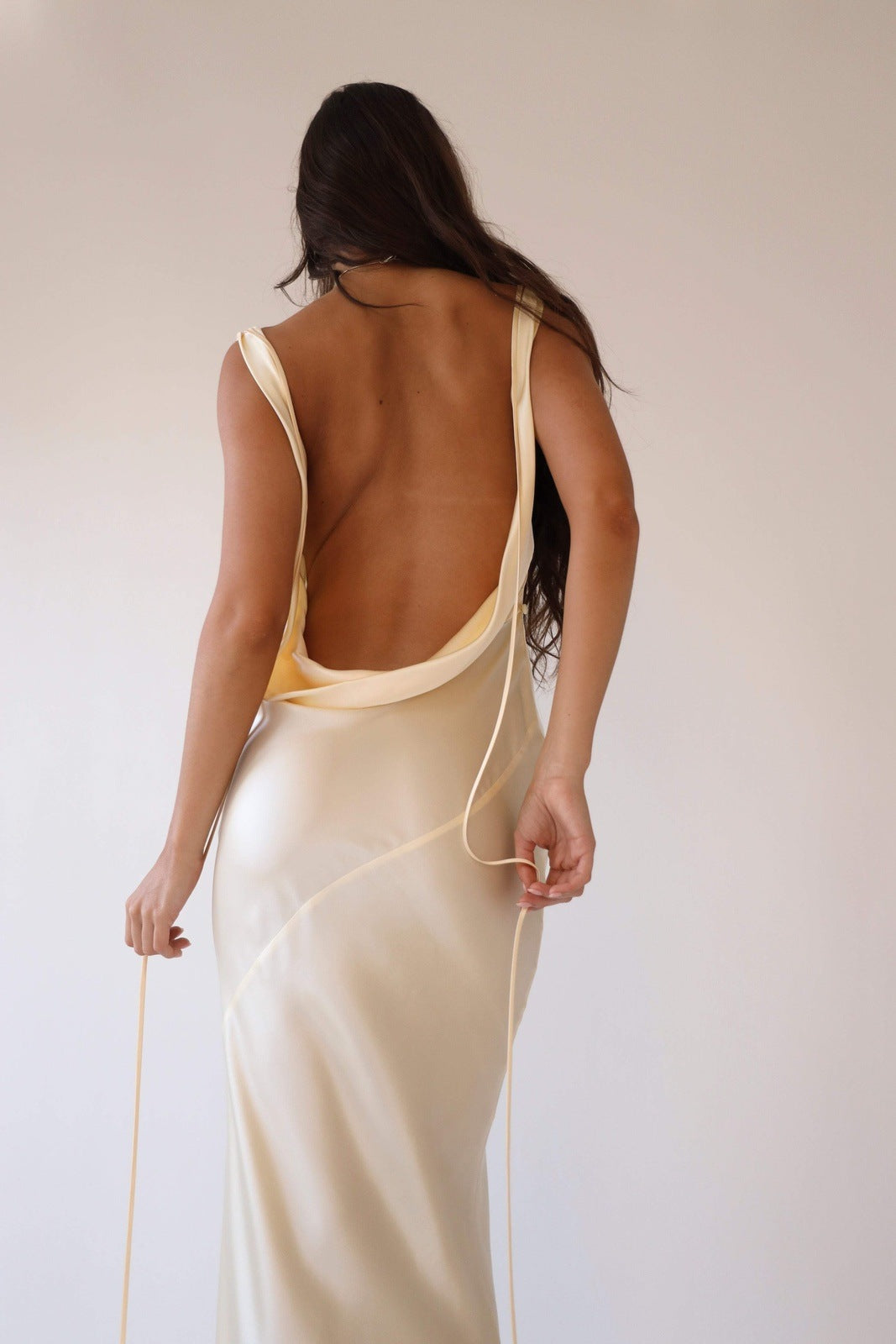 Woman wearing ivory silk cowl neck slip dress
