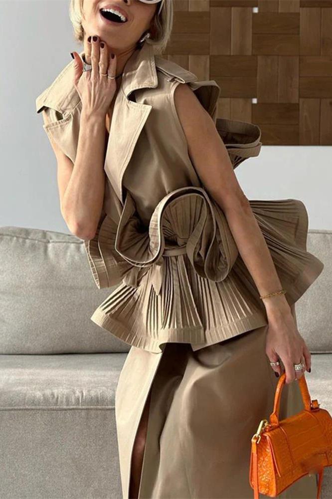 Woman wearing tan sleeveless trench vest with orange purse