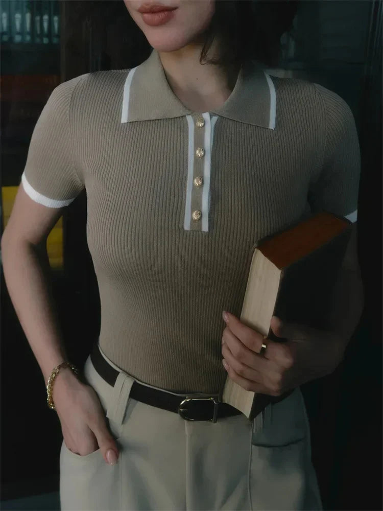 Woman wearing white ribbed knit polo shirt with brown belt and beige trousers