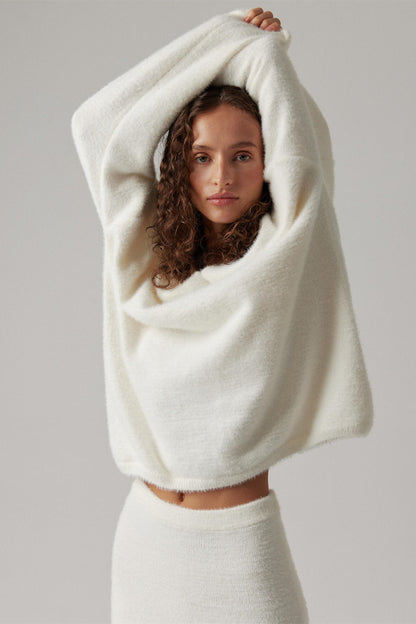 Woman in off-white boucle knit sweater and maxi skirt set with fuzzy slippers