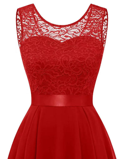Gold - A woman wearing a sleeveless burgundy high-low dress with a textured lace bodice and a flowing chiffon skirt, paired with silver strappy heels.