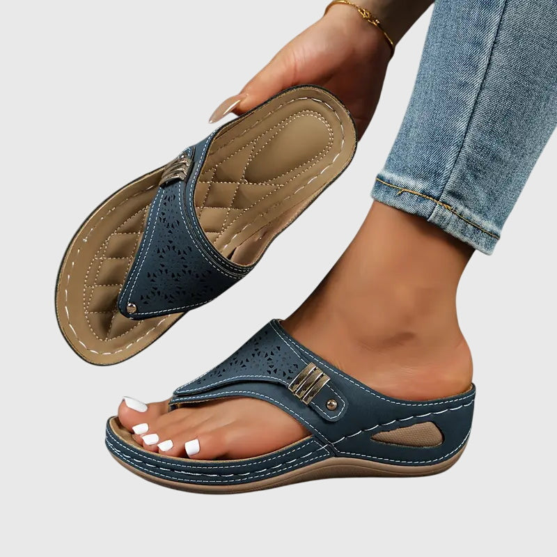 Navy - Faux-leather wedge sandals featuring laser-cut upper detailing, a decorative side buckle, contoured stitched footbed, and contrast stitching along the sole