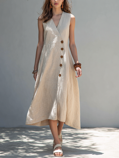 Oatmeal - Woman walking outdoors wearing a sleeveless V-neck midi dress with an asymmetrical button-front closure and sweeping hemline.