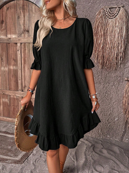 Black - A woman wearing a navy blue linen-blend sundress with puff sleeves, ruffle cuffs, and a flounce hem, holding a straw hat.