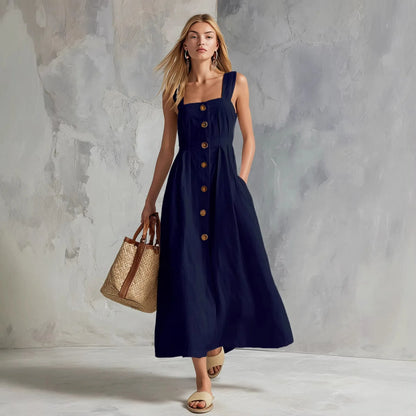 Navy - A woman modeling a chocolate brown linen-blend midi sundress with a square neckline, wide straps, and a button-down front, holding a woven straw tote bag.